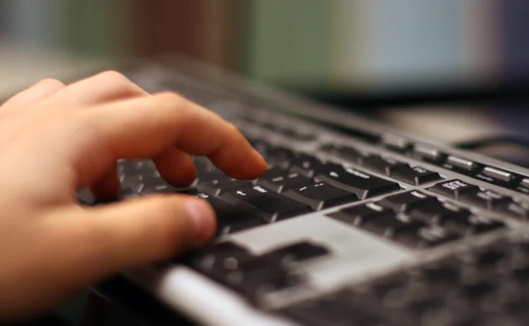 A hand on a computer keyboard