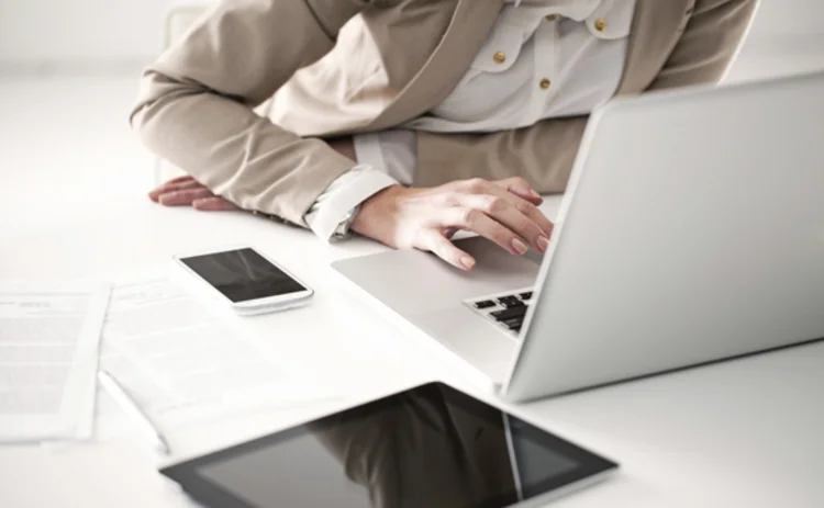 Worker with laptop and smartphone and tablet